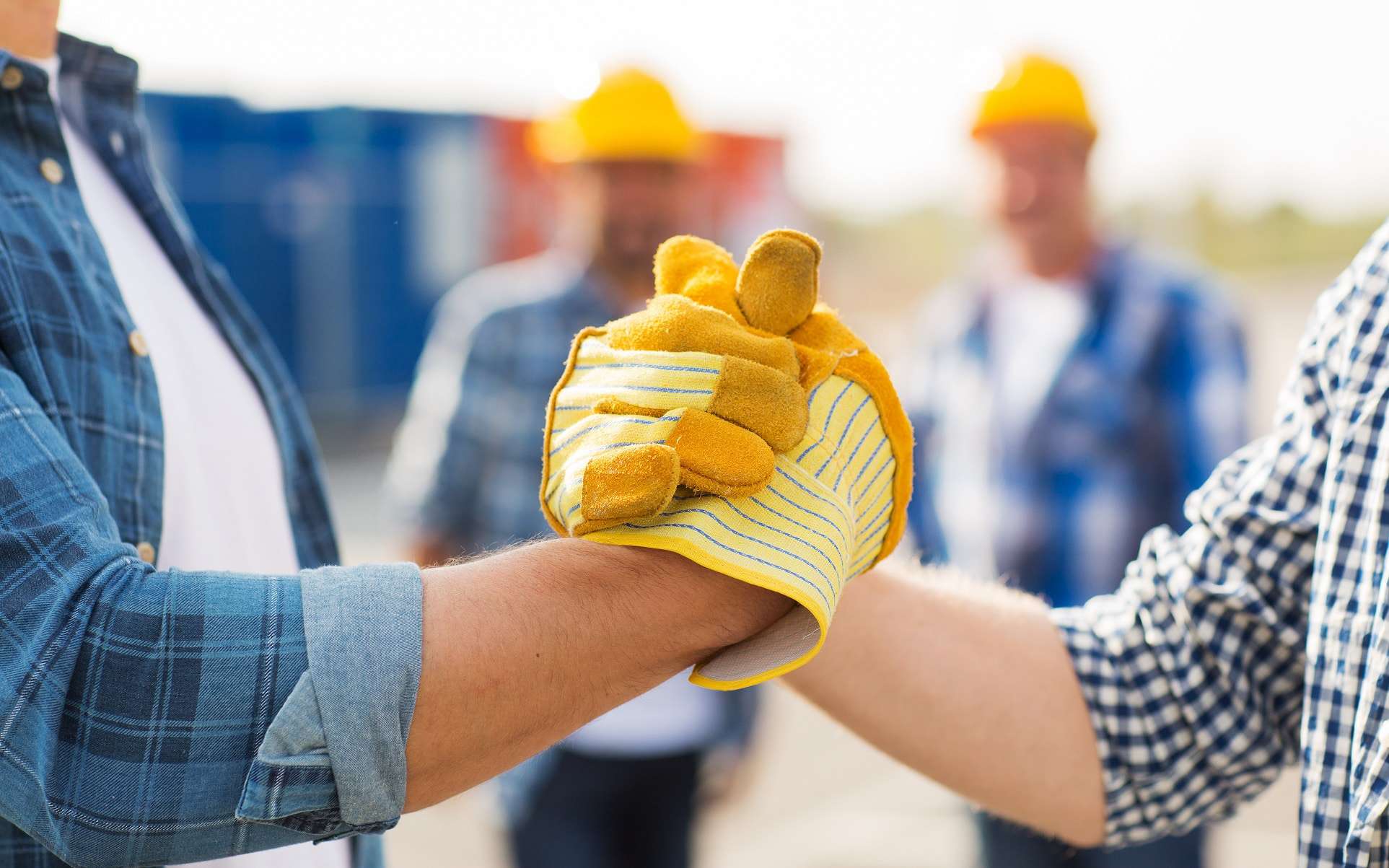 Multiple skilled tradesmen shaking hands after meeting a recently hired skilled trades person.