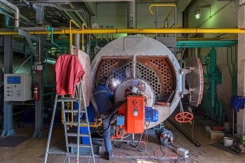 Boilermaker welding on and repairing a firetube boiler.