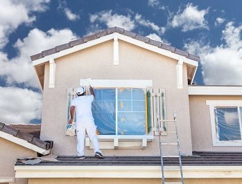 A painter is painting a house.