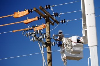 A linesmen is repairing a utility electrical power line from a bucket truck.