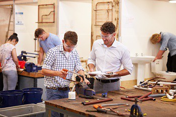 Plumber apprentices learning the plumbing trade.